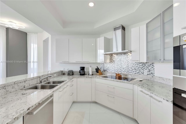 kitchen featuring light stone counters, white cabinetry, sink, black appliances, and wall chimney exhaust hood