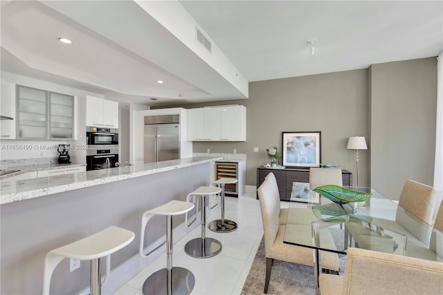 dining room featuring wine cooler and light tile patterned flooring