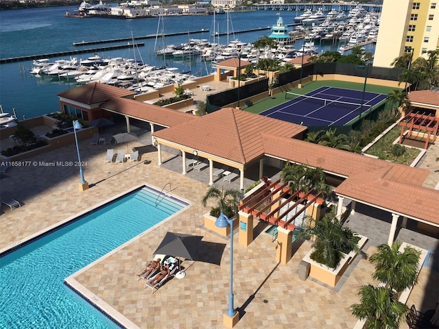 view of swimming pool featuring a water view and a patio