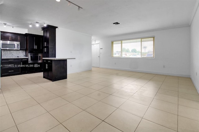 kitchen with ornamental molding, backsplash, stainless steel appliances, a kitchen breakfast bar, and a kitchen island