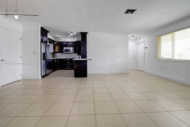 kitchen featuring a center island, light tile patterned floors, stainless steel appliances, and tasteful backsplash