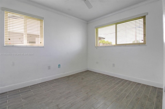 spare room featuring dark wood-type flooring, ceiling fan, and ornamental molding