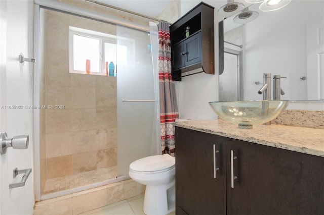 bathroom featuring vanity, toilet, an enclosed shower, and tile patterned flooring