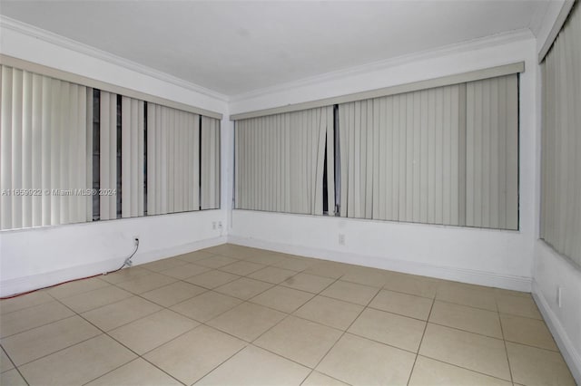 spare room featuring crown molding and light tile patterned flooring