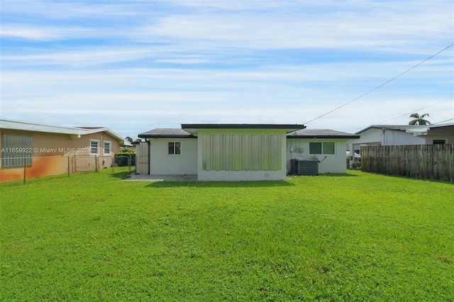 back of house featuring a yard and central AC unit