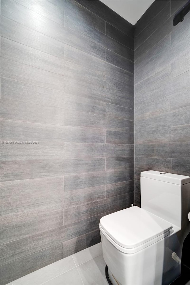 bathroom featuring tile walls, toilet, and tile patterned floors