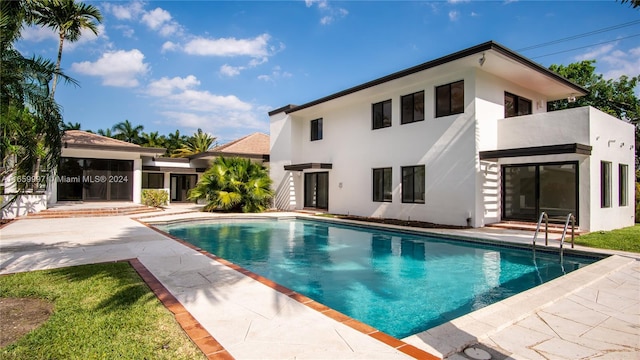back of house featuring an outdoor pool, stucco siding, and a patio area