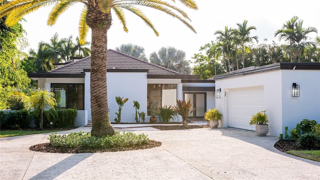 view of front facade with curved driveway, stucco siding, and an attached garage