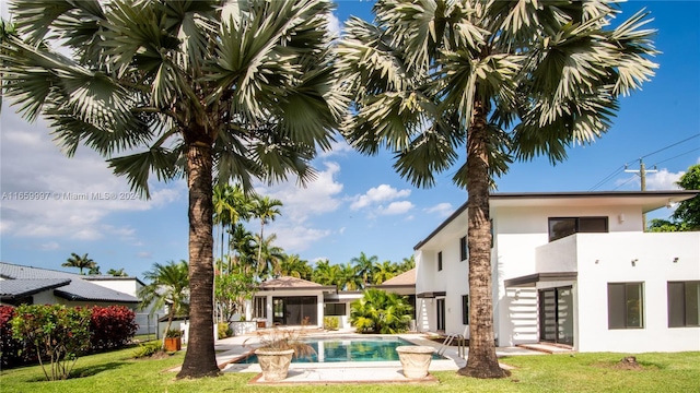 exterior space with a lawn, a patio, and a fenced in pool