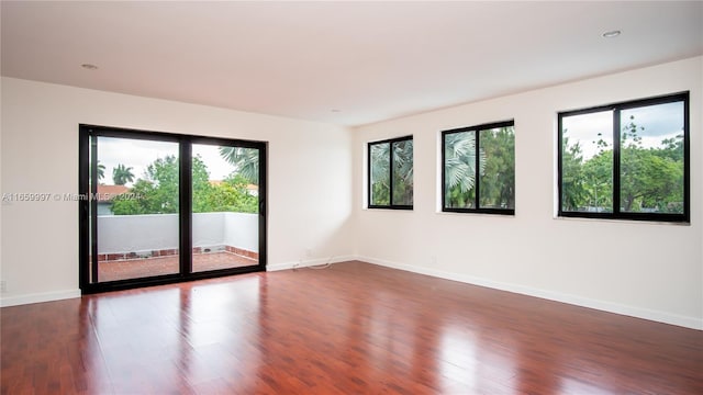 spare room featuring dark wood-style floors, baseboards, and recessed lighting