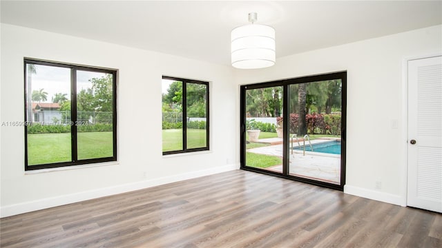 spare room featuring baseboards and wood finished floors