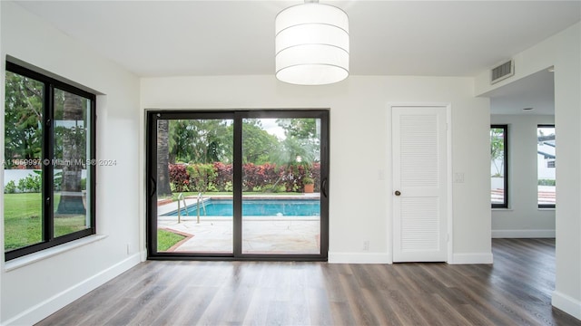 spare room with baseboards, visible vents, and wood finished floors