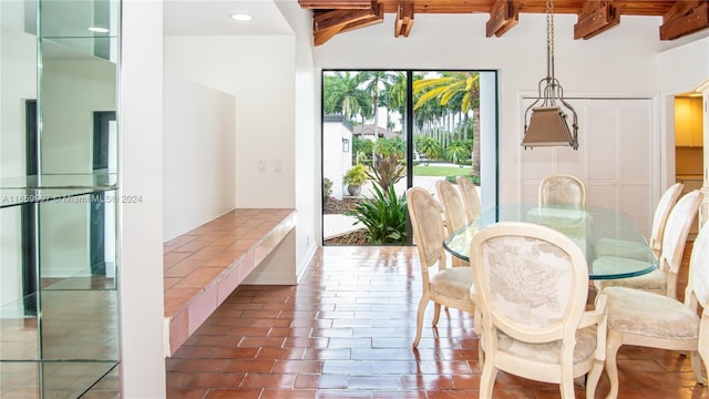 dining space with beamed ceiling