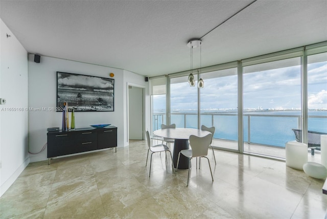 665 NE 25th St Unit 1704, Miami, FL 33137 - dining area featuring floor to ceiling windows, a water view, and a textured ceiling