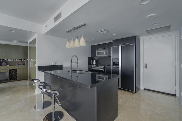 kitchen featuring a kitchen breakfast bar, pendant lighting, kitchen peninsula, sink, and stainless steel appliances