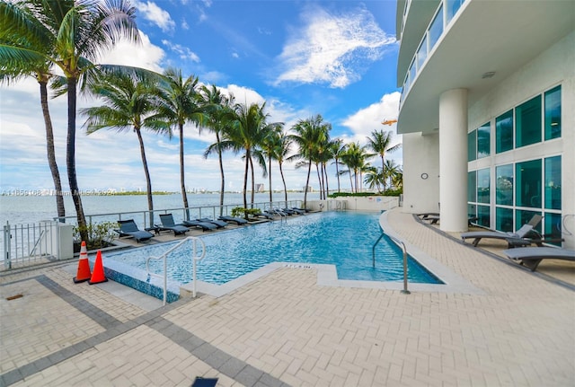 view of pool featuring a patio area and a water view