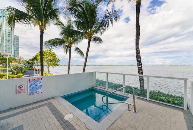 view of swimming pool with a community hot tub and a water view