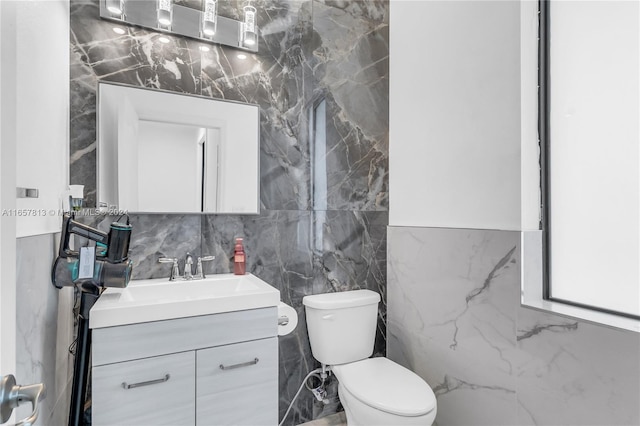 bathroom featuring tile walls, toilet, and vanity