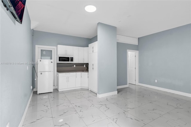 kitchen with white cabinetry and white appliances