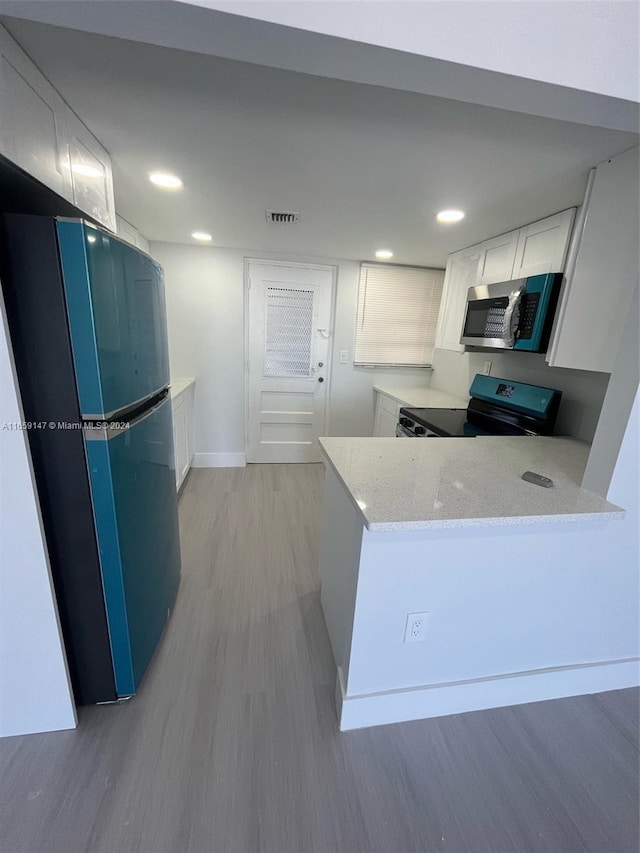 kitchen featuring white cabinets, kitchen peninsula, fridge, black range with electric cooktop, and light hardwood / wood-style flooring