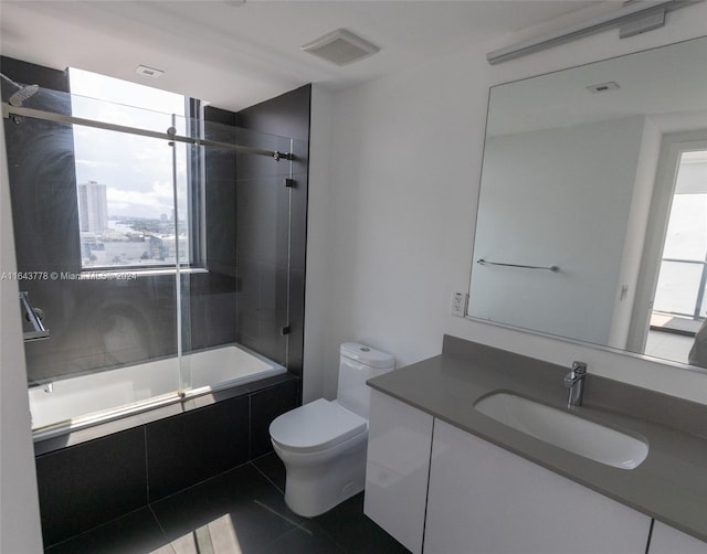 full bathroom with tile patterned flooring, tiled shower / bath, toilet, and vanity