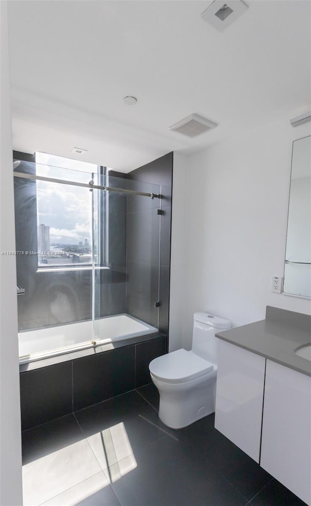 full bathroom with shower / bath combination with glass door, vanity, toilet, and tile patterned flooring