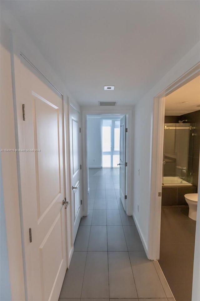 hall featuring light tile patterned floors