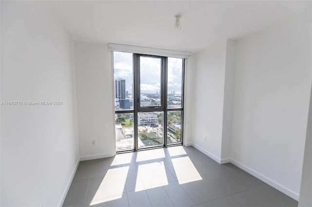 tiled spare room with a wall of windows