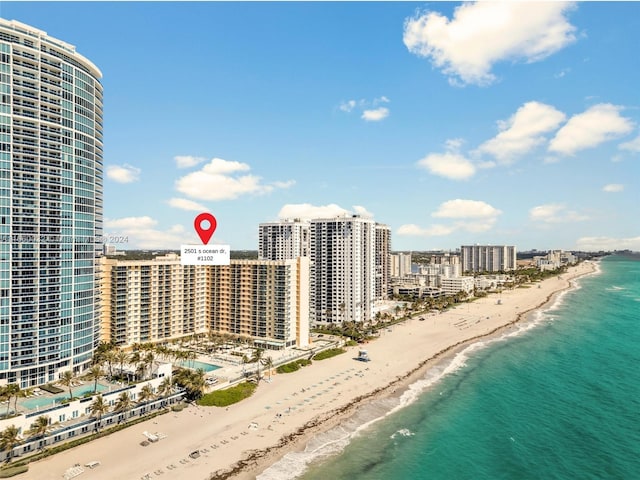 drone / aerial view featuring a water view and a beach view