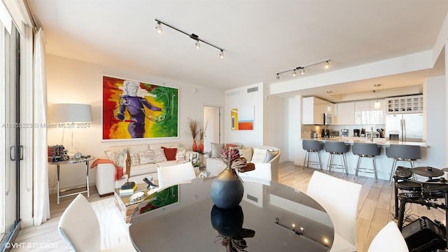 dining area featuring light hardwood / wood-style flooring and rail lighting