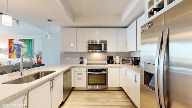 kitchen with white cabinetry, sink, pendant lighting, and stainless steel appliances