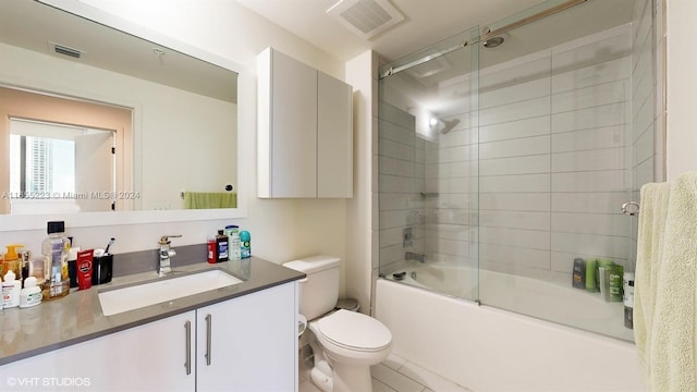 full bathroom with enclosed tub / shower combo, vanity, and toilet