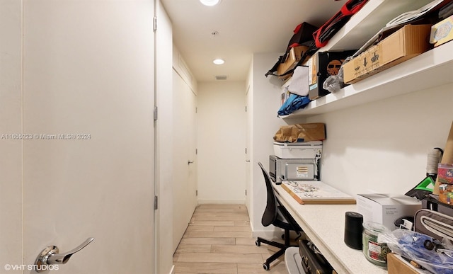 home office with light hardwood / wood-style flooring