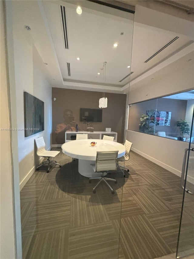 carpeted dining area featuring a tray ceiling