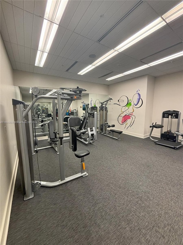 workout area featuring carpet and a paneled ceiling