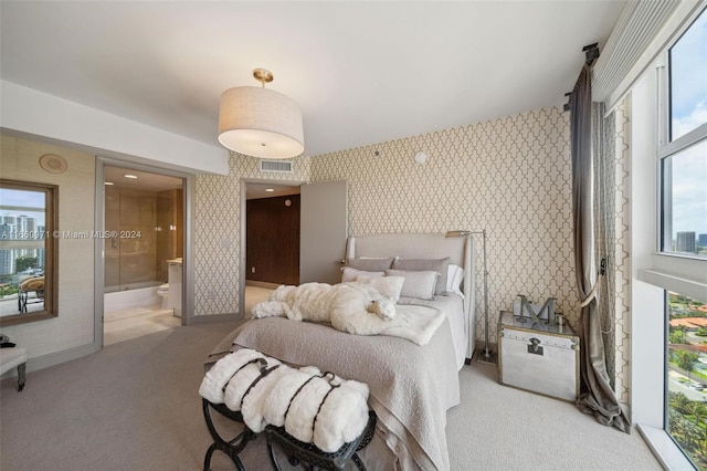 bedroom featuring light colored carpet and ensuite bathroom