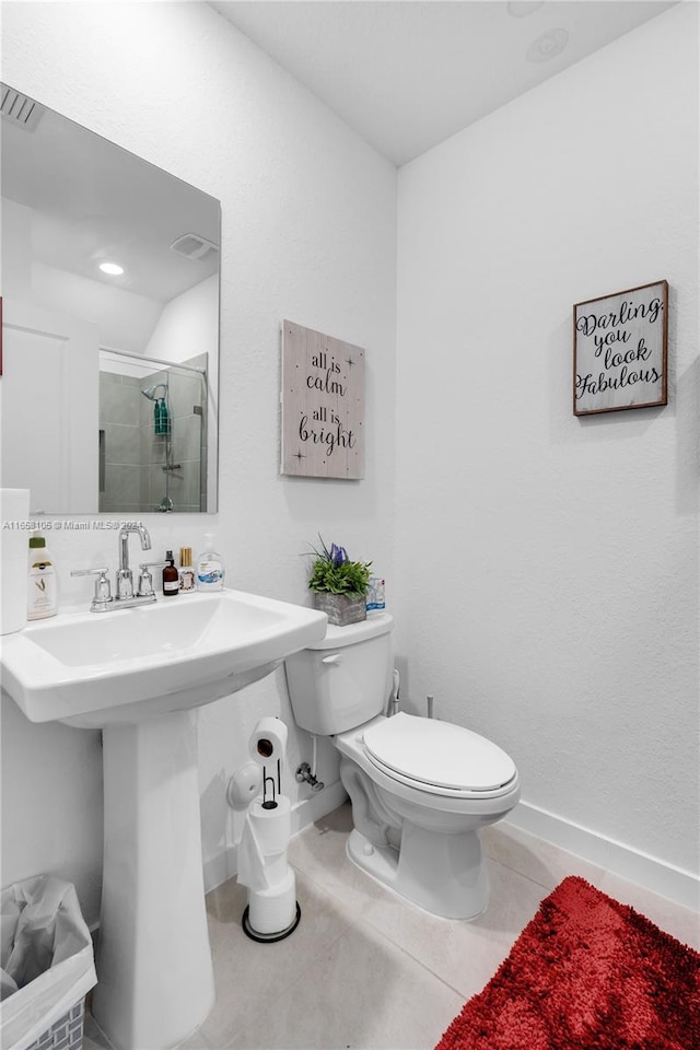 bathroom with toilet, a shower with shower door, and tile patterned floors