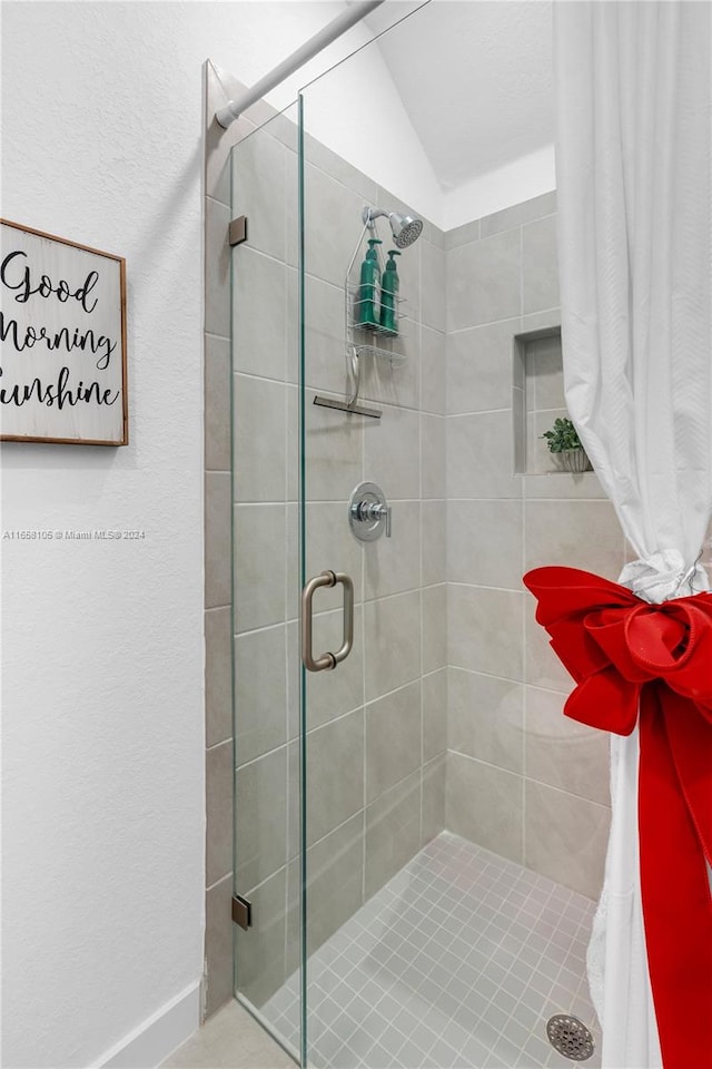 bathroom featuring lofted ceiling and an enclosed shower