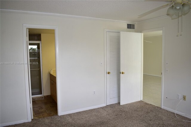 carpeted spare room with a textured ceiling, crown molding, and ceiling fan