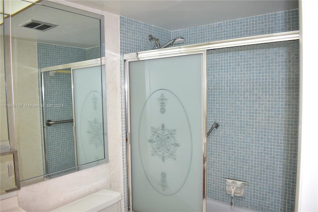 bathroom featuring tile walls and toilet