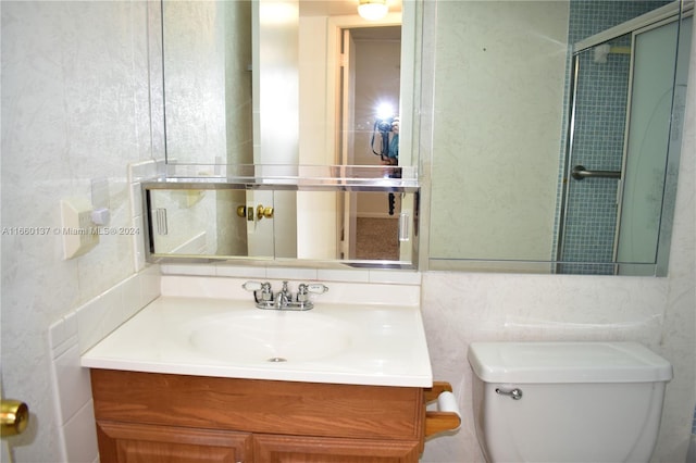 bathroom featuring toilet, a shower with door, and vanity