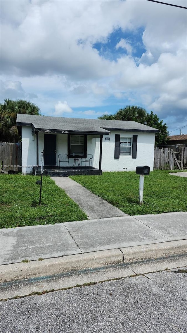 ranch-style home with a front yard and a porch