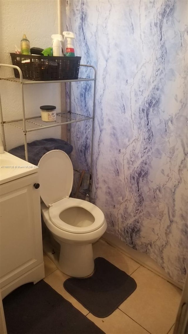 bathroom with a shower with shower curtain, toilet, and tile patterned flooring