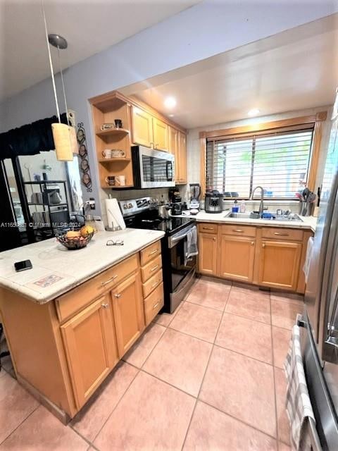 kitchen with hanging light fixtures, stainless steel appliances, sink, kitchen peninsula, and light tile patterned flooring