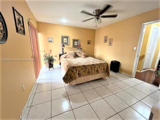 tiled bedroom featuring ceiling fan