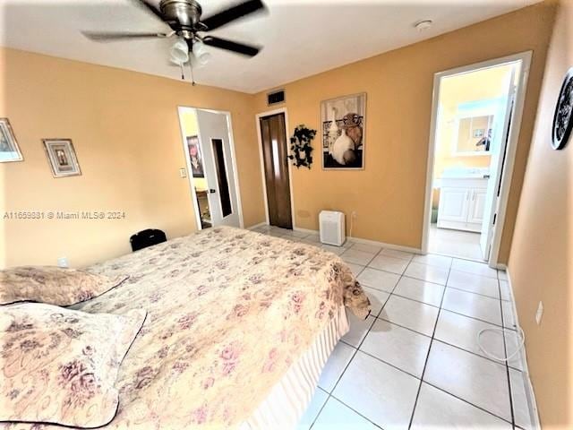 tiled bedroom featuring ensuite bath and ceiling fan