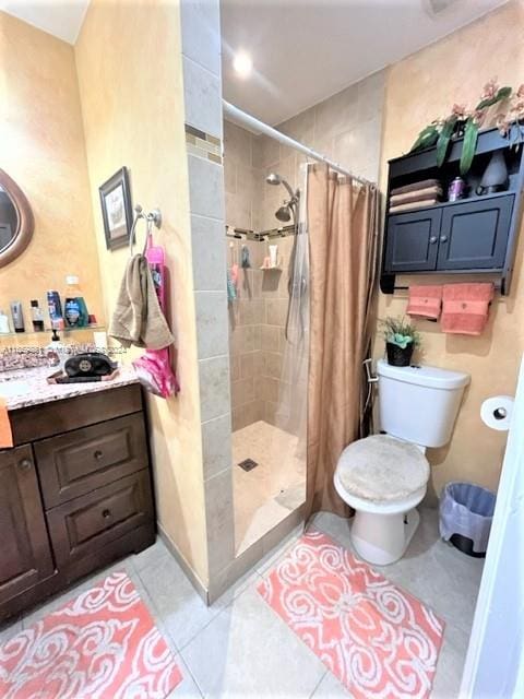 bathroom featuring tile patterned flooring, vanity, toilet, and walk in shower