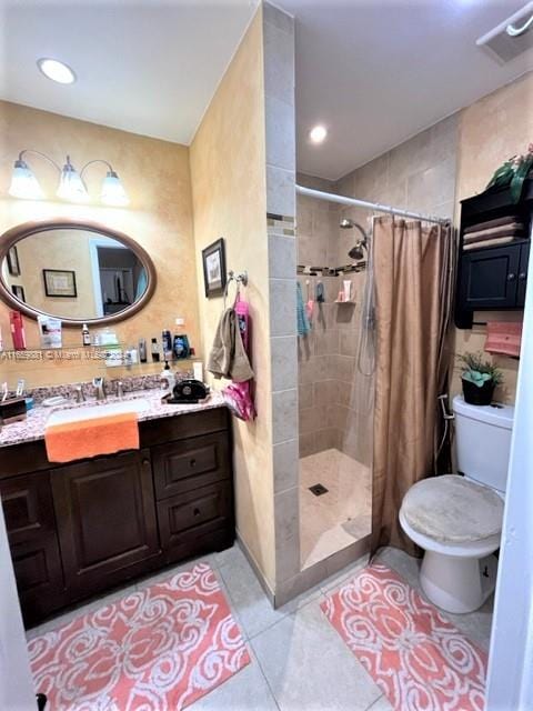 bathroom with a shower with shower curtain, toilet, vanity, and tile patterned floors