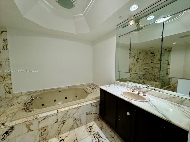 bathroom with vanity and tiled tub