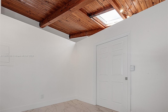 spare room featuring wood ceiling and a skylight